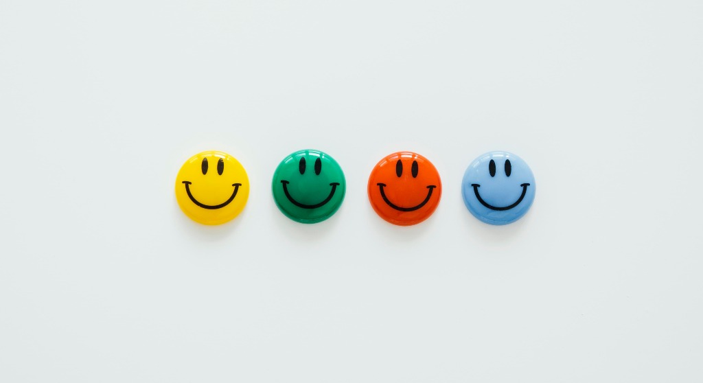 Cuatro smileys que representan las claves para ser felices