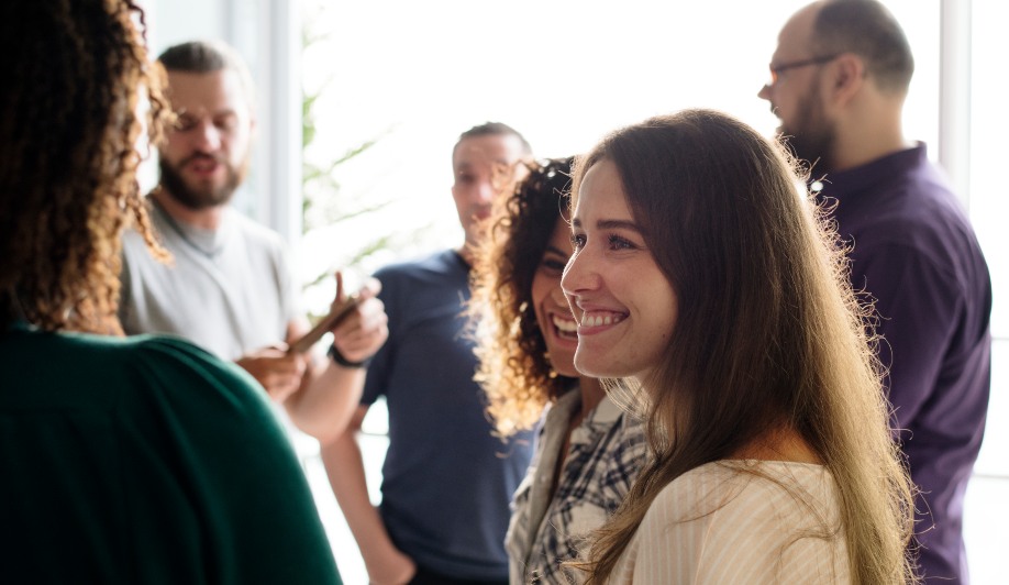 Grupo de profesionales charlando en inglés en un evento de networking.