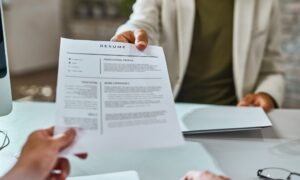 Candidato entregando su CV en inglés para una entrevista de trabajo.