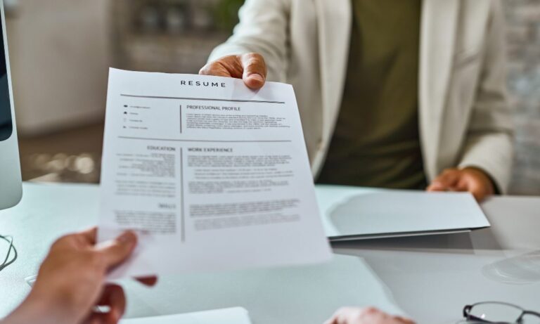 Candidato entregando su CV en inglés para una entrevista de trabajo.