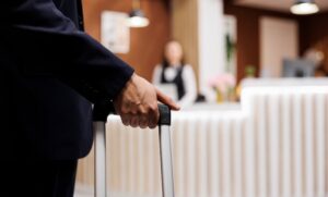 Recepcionista de hotel eesperando para atender a un huesped en inglés.